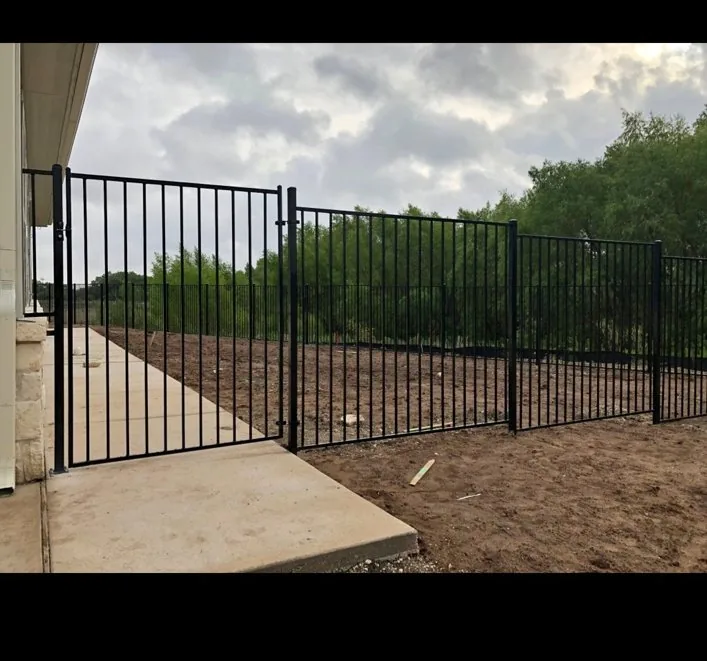 Black ornamental metal fence and pedestrian gate